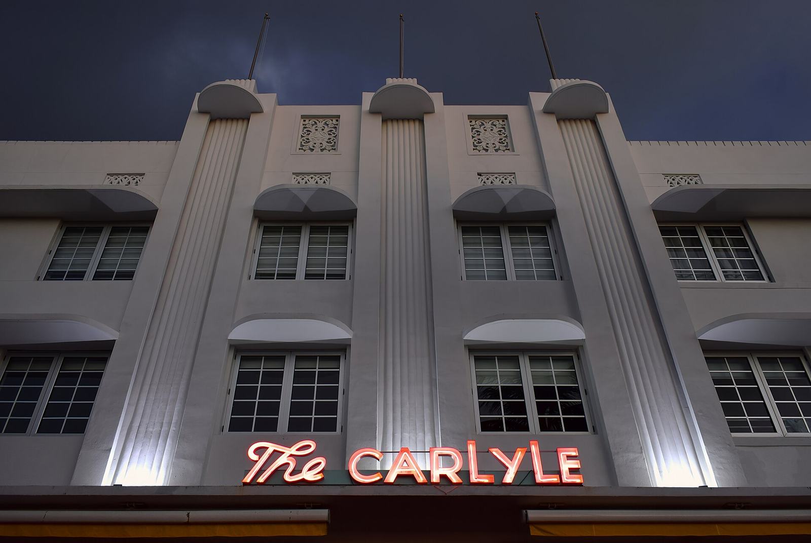 The Carlyle hotel's neon sign glowing at night on Ocean Drive, Miami Beach